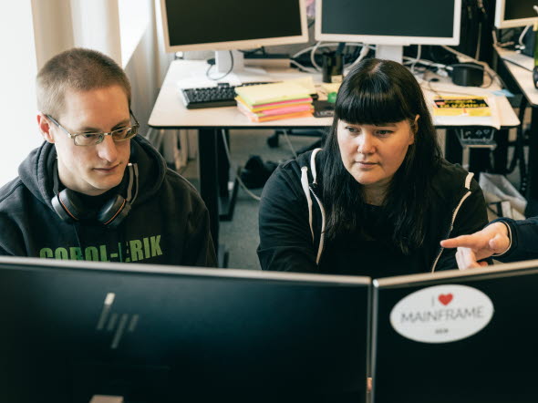 Bild på två personer som tittar på en dataskärm och lär sig COBOL.