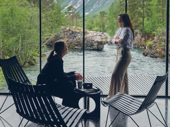 Women in dialogue in front of a window