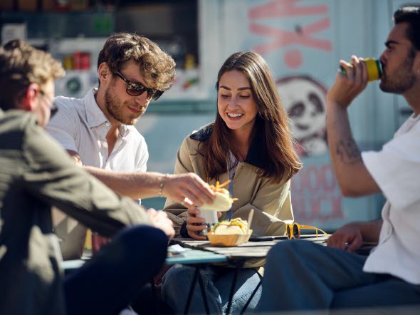 Picture of some friends eating lunch together in the sun. Picture of some friends eating lunch together in the sun.