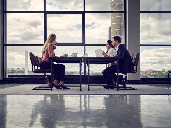 Office meeting, four people at a table