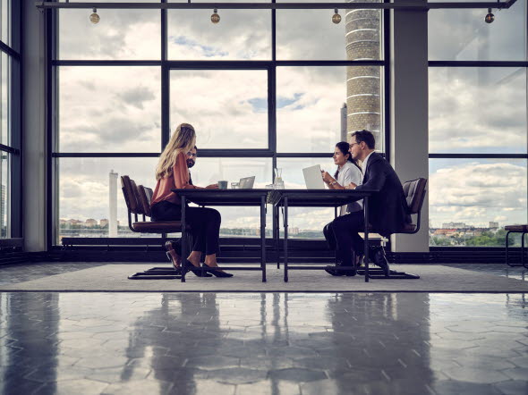 Four people having a meeting in a meeting room. Four people having a meeting in a meeting room.