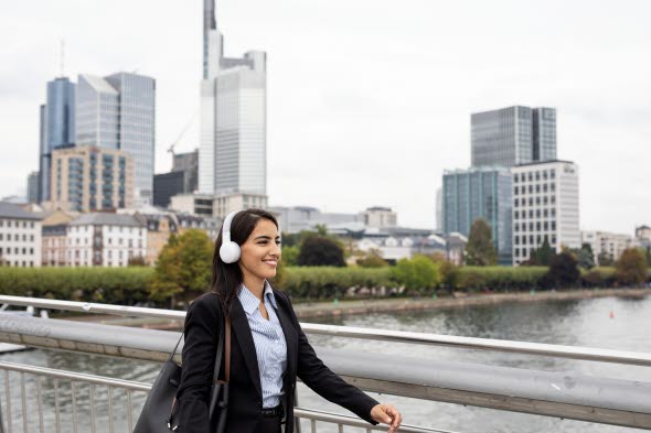Woman walking on a bridge wearing headphones