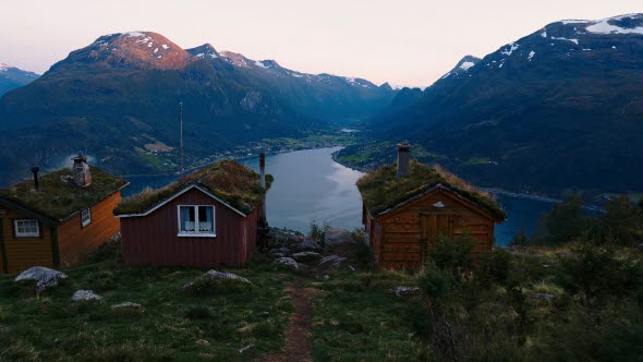 Bild på röda stugor i en fjord i Norge.