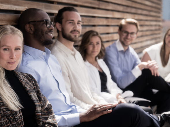 Colleagues sitting together on a bench in the sunlight. Colleagues sitting together on a bench in the sunlight.