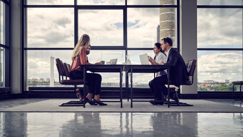 Four people having a meeting in a meeting room.