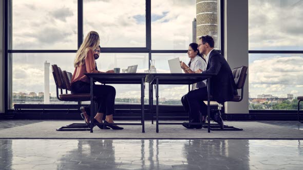 Office meeting, four people at a table