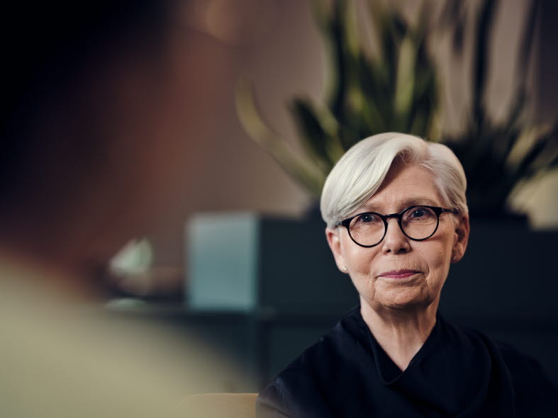 Äldre kvinna med glasögon och svart blus