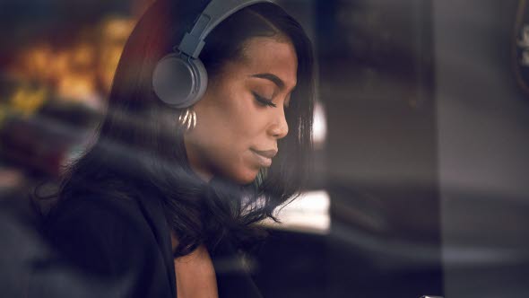 Woman with headphones holding a mobile phone