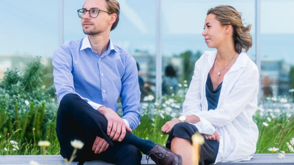 Two trainees sitting outdoors on a bench