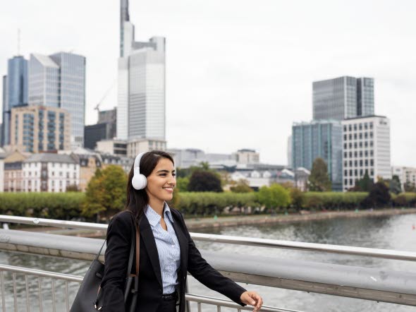 Image of woman with headphones walking in the city.