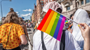 Människor som viftar med en prideflagga.