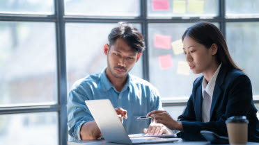 Two persons looking at a computer